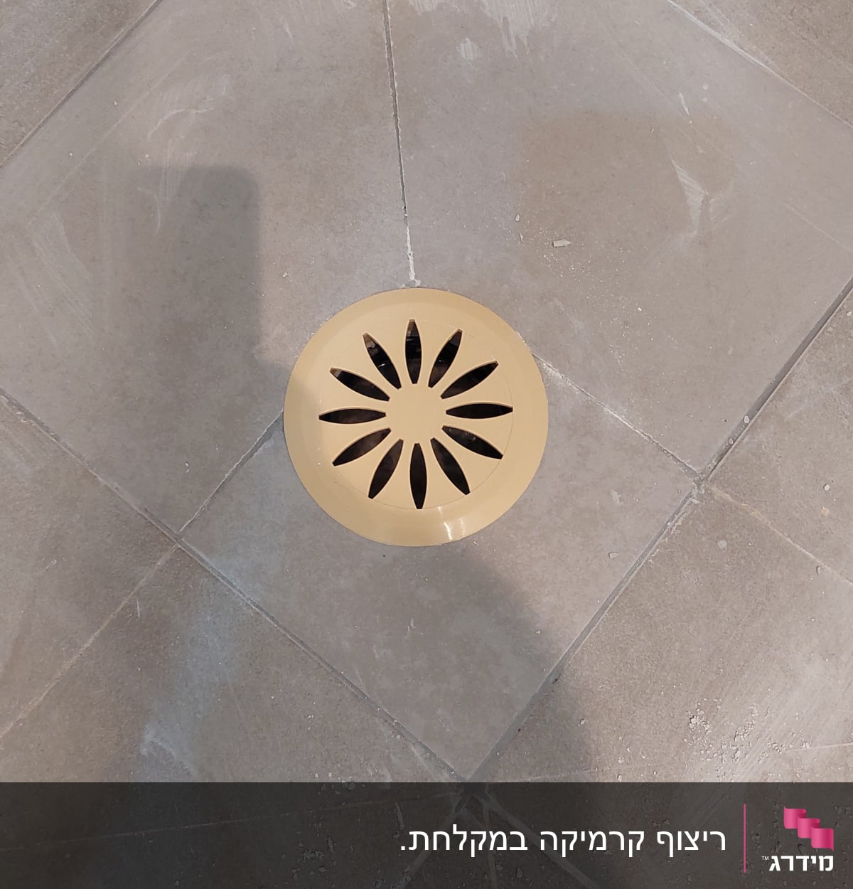 רצפת אריחים עם ניקוז עגול במרכז